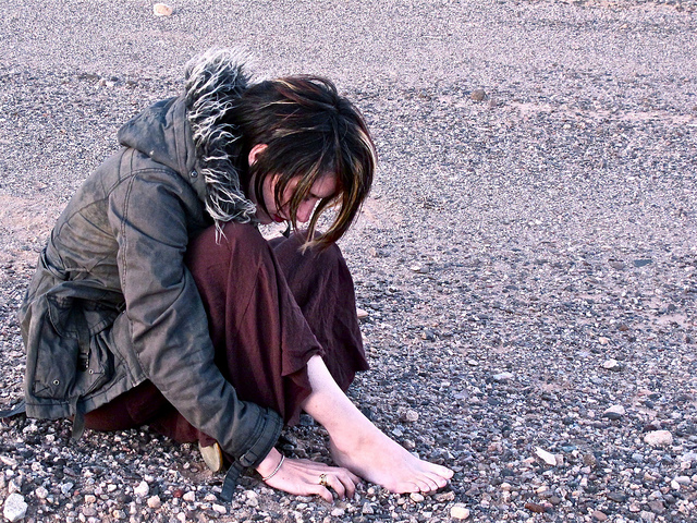 A woman sits on the ground. 