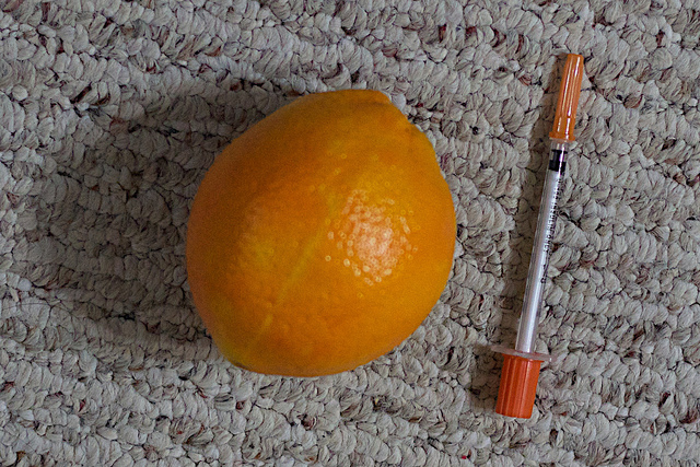 An orange and an insulin stick. 