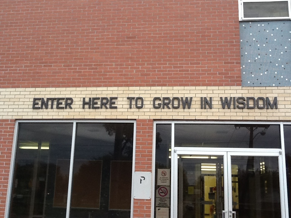 School door that reads "Enter here to grow in wisdom." 