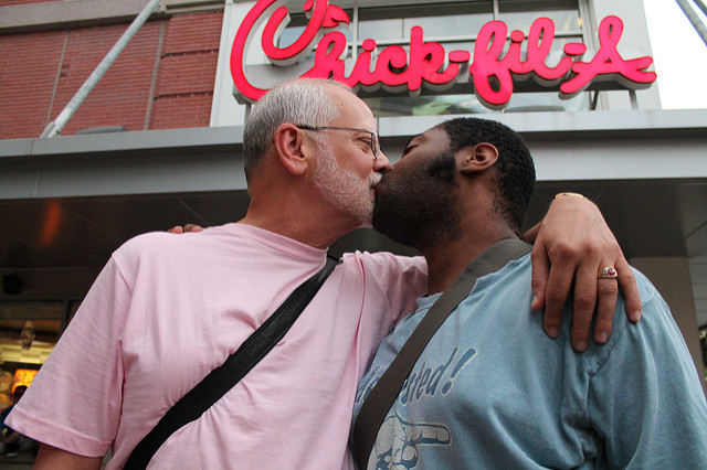 A Gay couple kisses in front of a Chick-fil-A