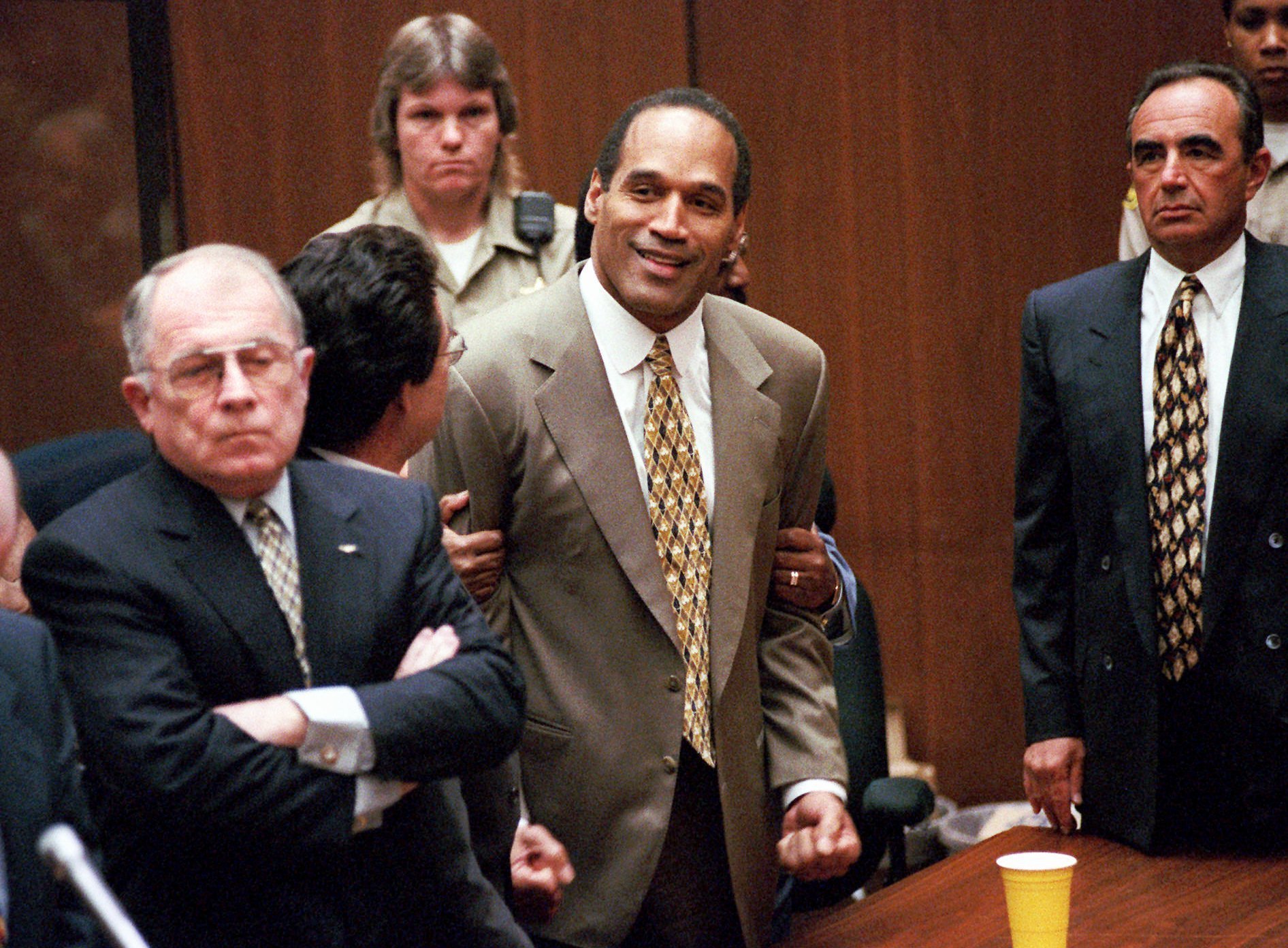 "In this Oct. 3, 1995, file photo, O.J. Simpson, center, clenches his fists in victory after the jury said he was not guilty in the murders of his ex-wife Nicole Brown Simpson and her friend Ronald Goldman in a Los Angeles courtroom."