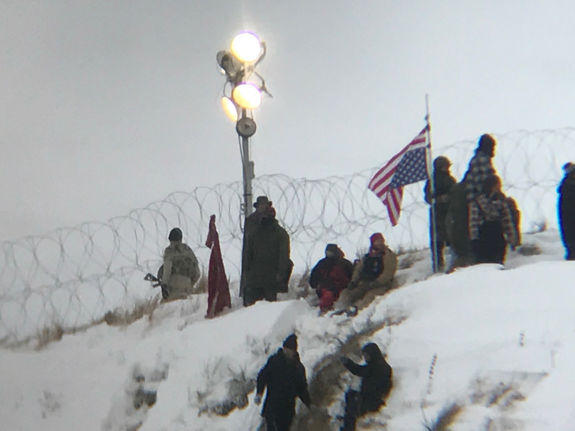 Protesters place a flag on Turtle Hill. 