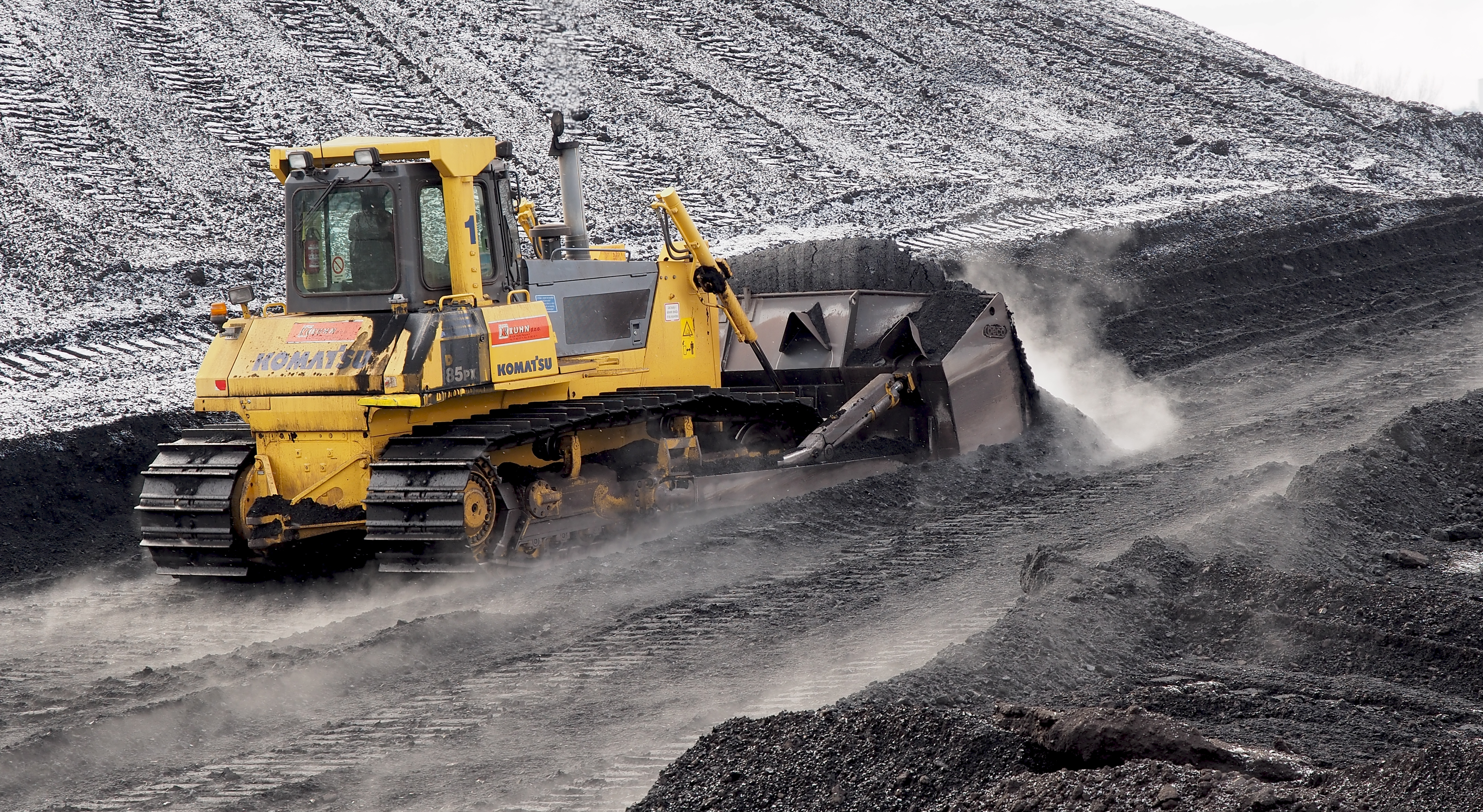 A bulldozer pushing coal. 