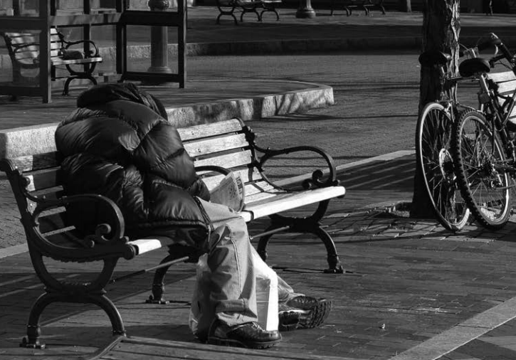 A homeless person on a bench. 