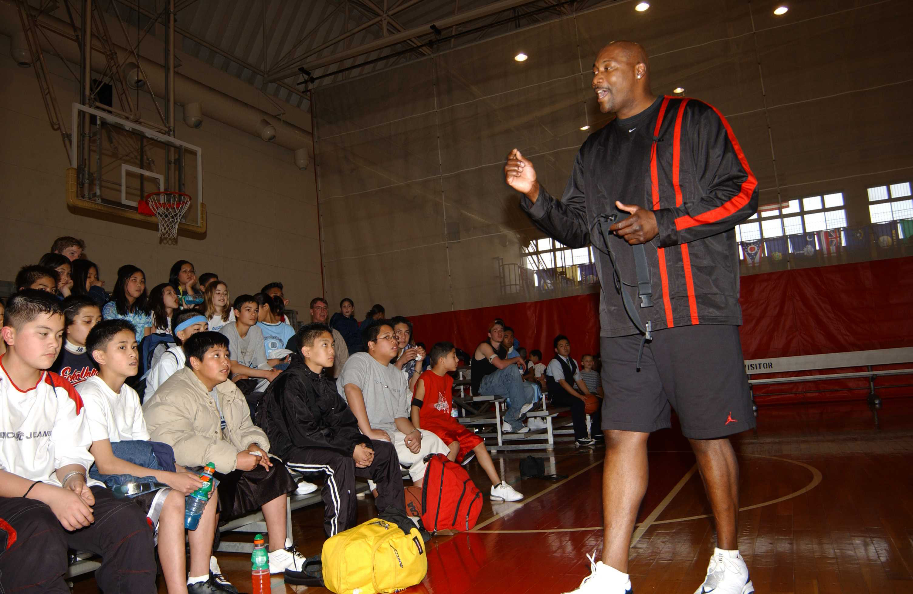 Former NBA player Jerome Kersey addresses a group of kids on the basketball court in the Naval Air Facility, Ranger Gym