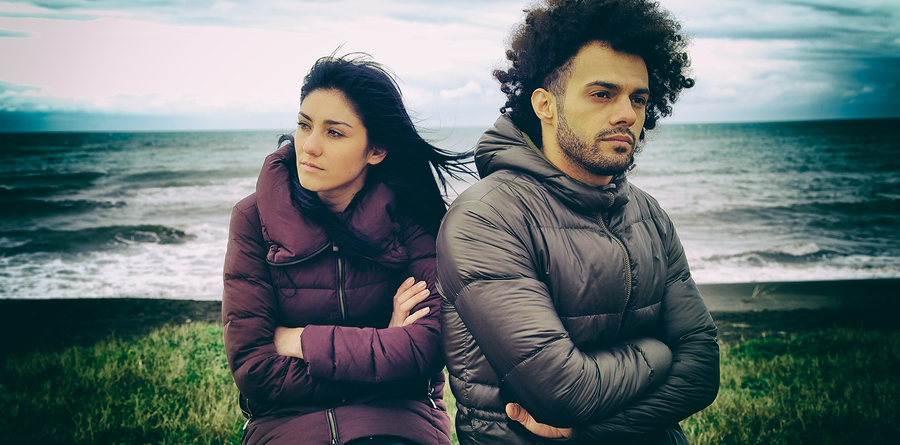 Sad couple having relationship problems in front of beach