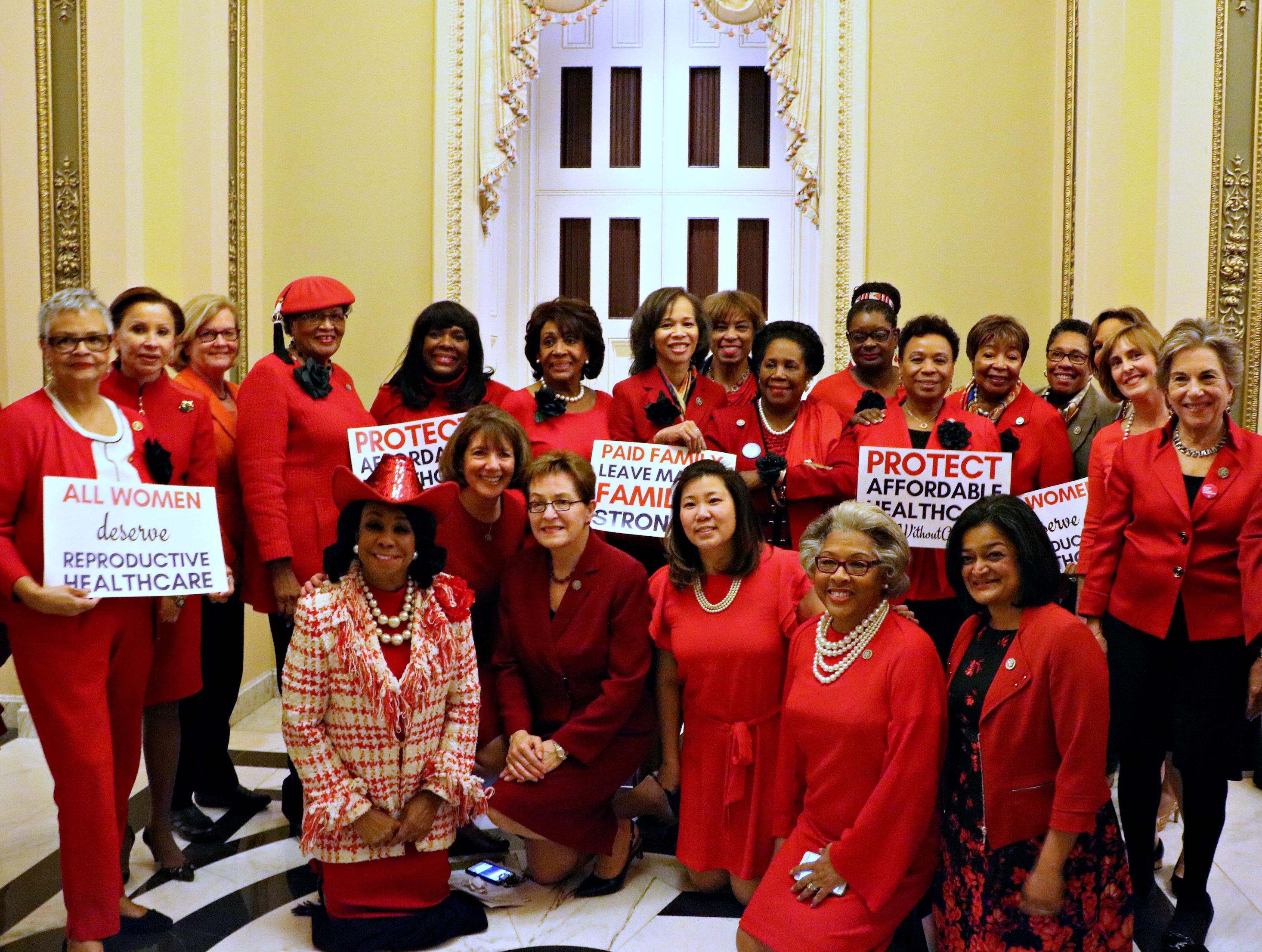 Women of the Congressional Black Caucus wearing red and black flowers. 