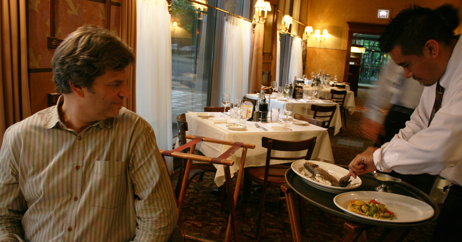 Man watching a restaurant worker serve food