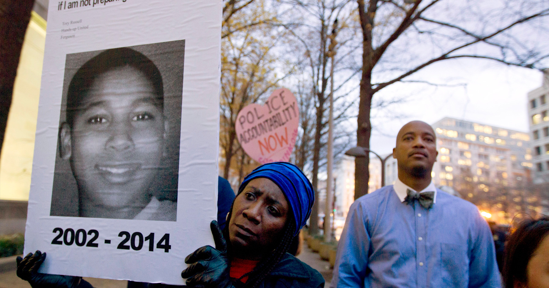 FILE - In a Monday, Dec. 1, 2014 file photo, Tomiko Shine holds up a picture of Tamir Rice, the 12 year old boy fatally shot on Nov. 22 by a rookie police officer, in Cleveland, Ohio, during a protest.