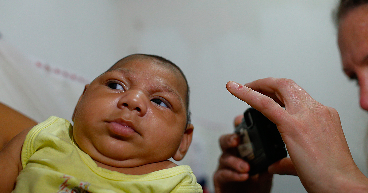 woman-taking-photo-of-baby-with-zika-virus